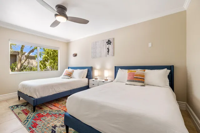 a bedroom with two beds and a painting on the wall