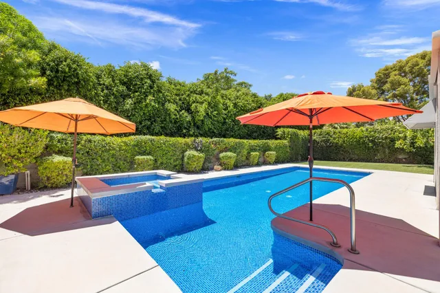 a view of a patio with chairs under an umbrella