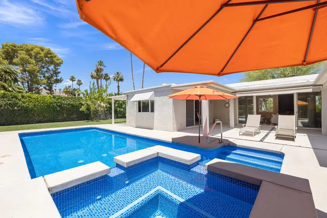 a view of a house with swimming pool and sitting area