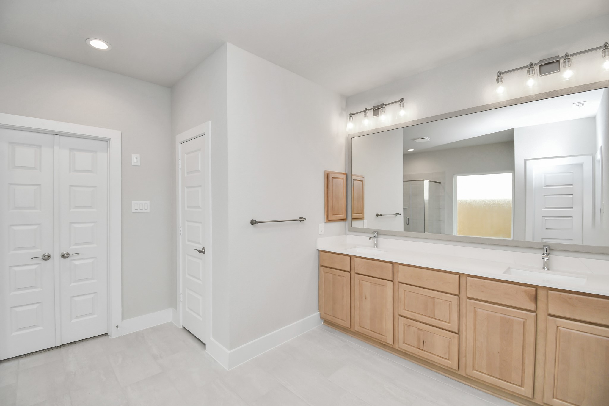 3106 Skerne Spring Dr Spring Spring, TX 77373 - Photo 27 of 47 Escape to a spa-like oasis in this primary bathroom. Enjoy a walk-in shower with tile surround, a separate garden tub with custom detailing, and an elegant vanity featuring light countertops, modern hardware, and beautiful vanity lights. Experience luxury and relaxation in every detail.