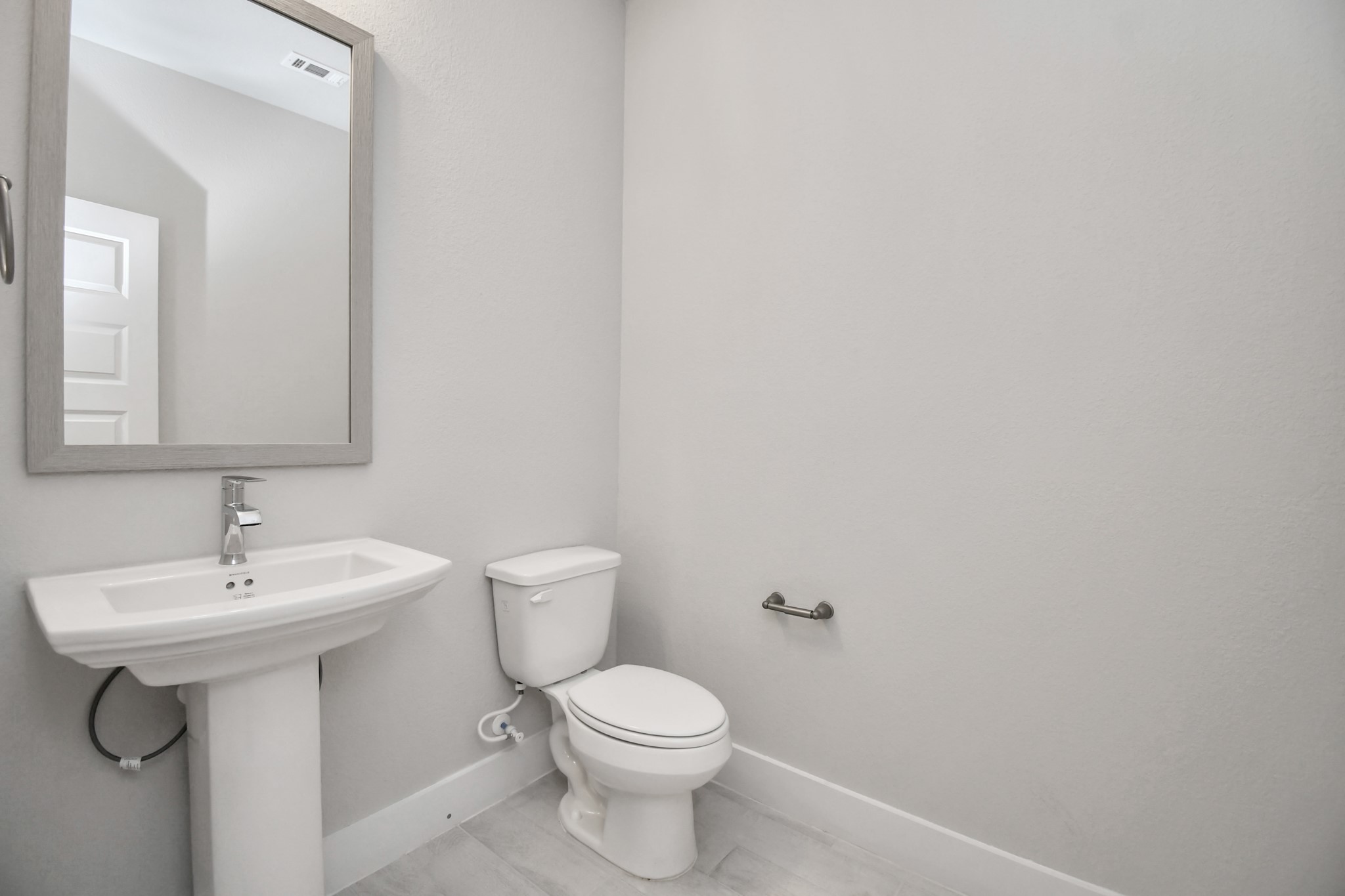 3106 Skerne Spring Dr Spring Spring, TX 77373 - Photo 9 of 47 This half bathroom features a stylish pedestal sink, modern hardware, and bright recessed lighting, creating a sleek and inviting space.