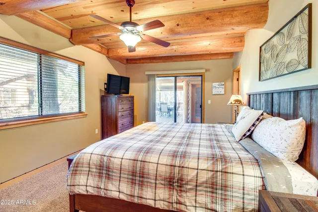 a bedroom with a large bed chandelier and a window