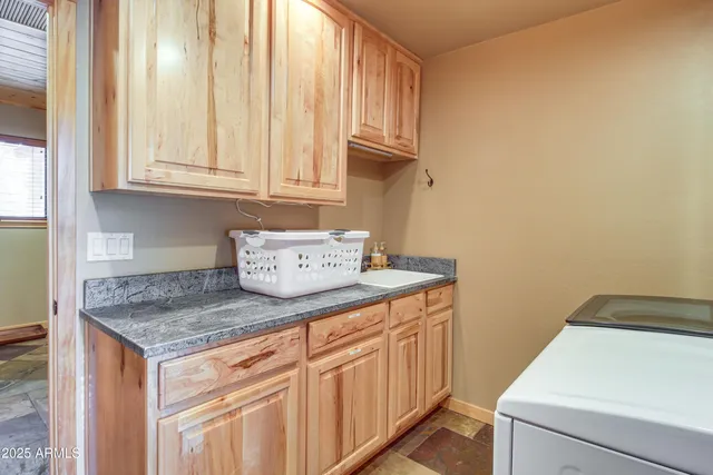 a utility room with granite countertop cabinets washer and dryer
