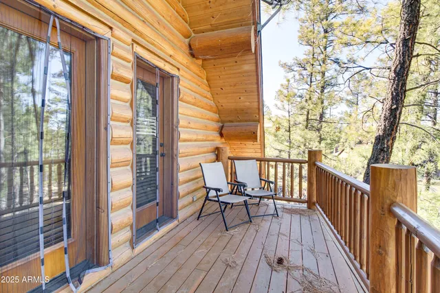 a balcony with wooden floor table and chairs