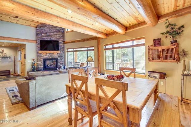 a dining hall with couches a flat screen tv and a fireplace