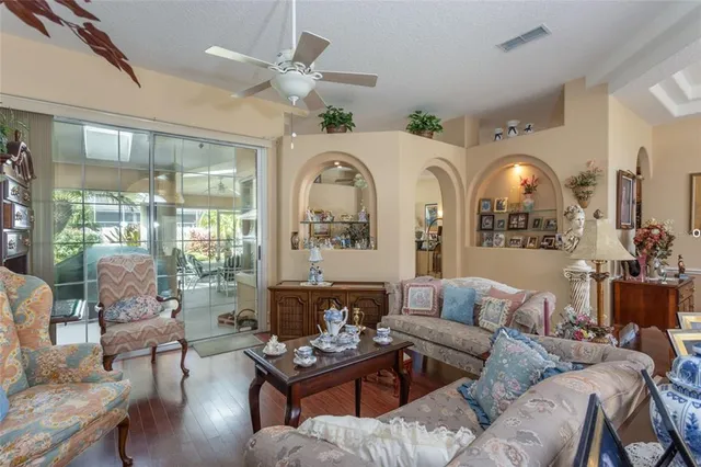 a living room with furniture chandelier and a large window