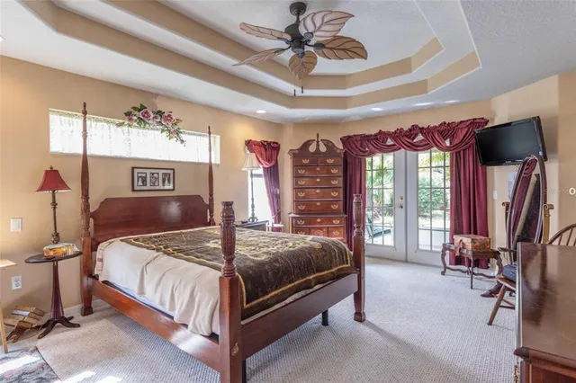 a bedroom with a bed a chandelier and dresser
