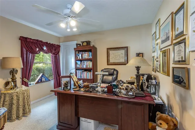 a work room with furniture large window and flat screen tv
