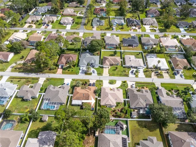 an aerial view of residential houses with outdoor space and parking