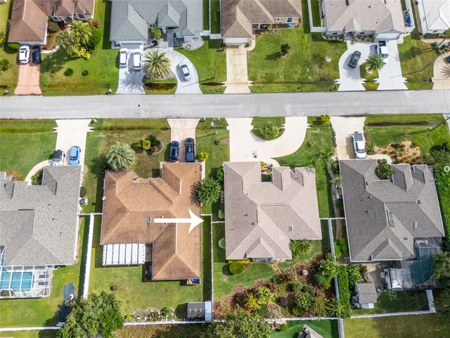 an aerial view of residential houses with outdoor space and parking