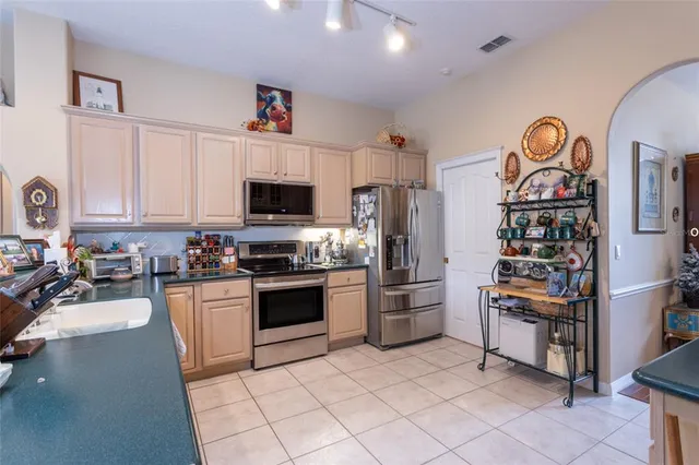a kitchen with stainless steel appliances granite countertop a refrigerator and a stove top oven