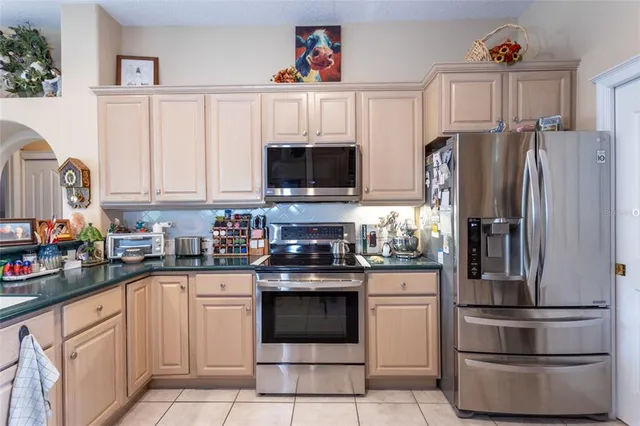 a kitchen with stainless steel appliances granite countertop a refrigerator sink stove and microwave