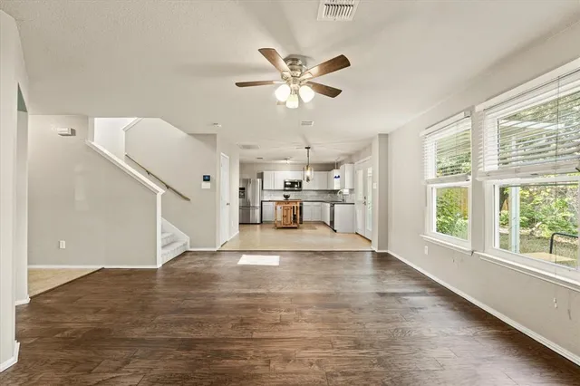 a view of a kitchen with wooden floor and electronic appliances