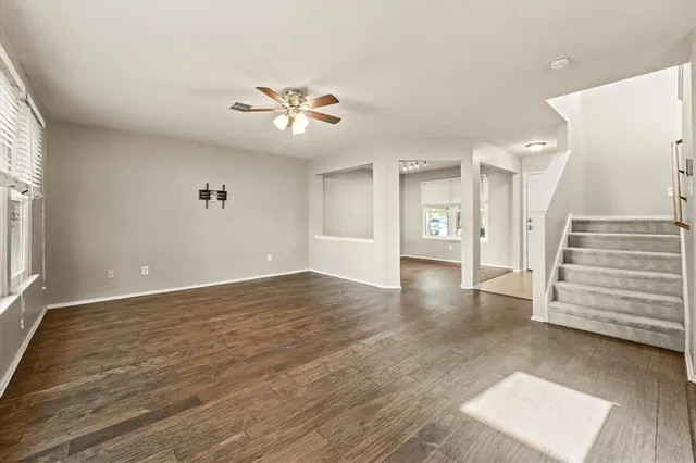 a view of an empty room with a window and a ceiling fan