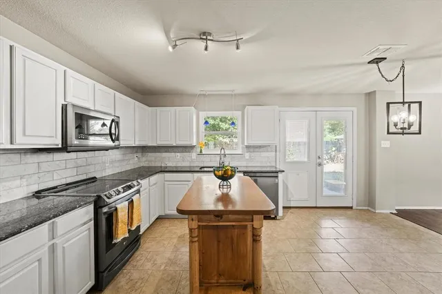 a kitchen with a stove a sink and a microwave