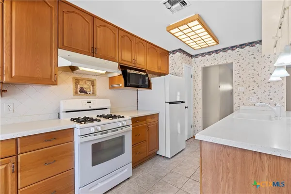 a kitchen with stainless steel appliances white cabinets and a stove top oven