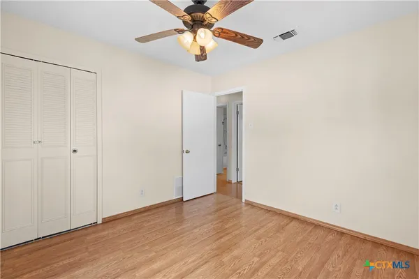 a view of an empty room with wooden floor