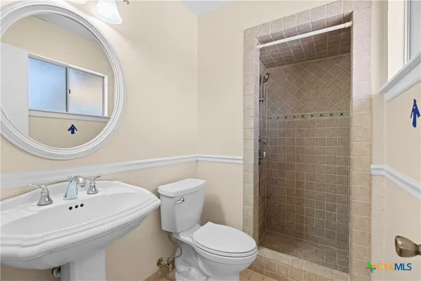 a bathroom with a sink a toilet and shower