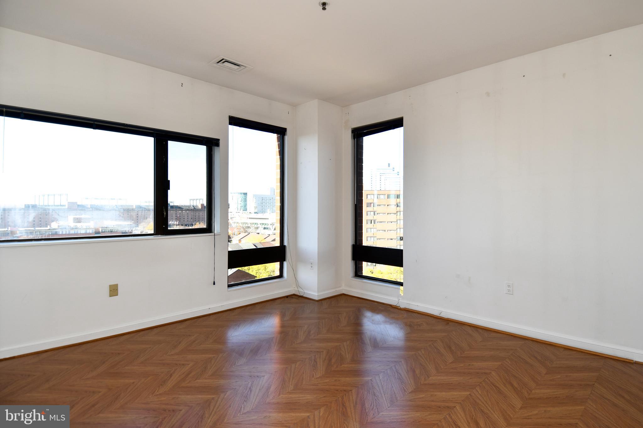 10 East Lee Street, Unit 809 Baltimore, MD 21202 - Photo 22 of 58 wooden floor in an empty room with a window