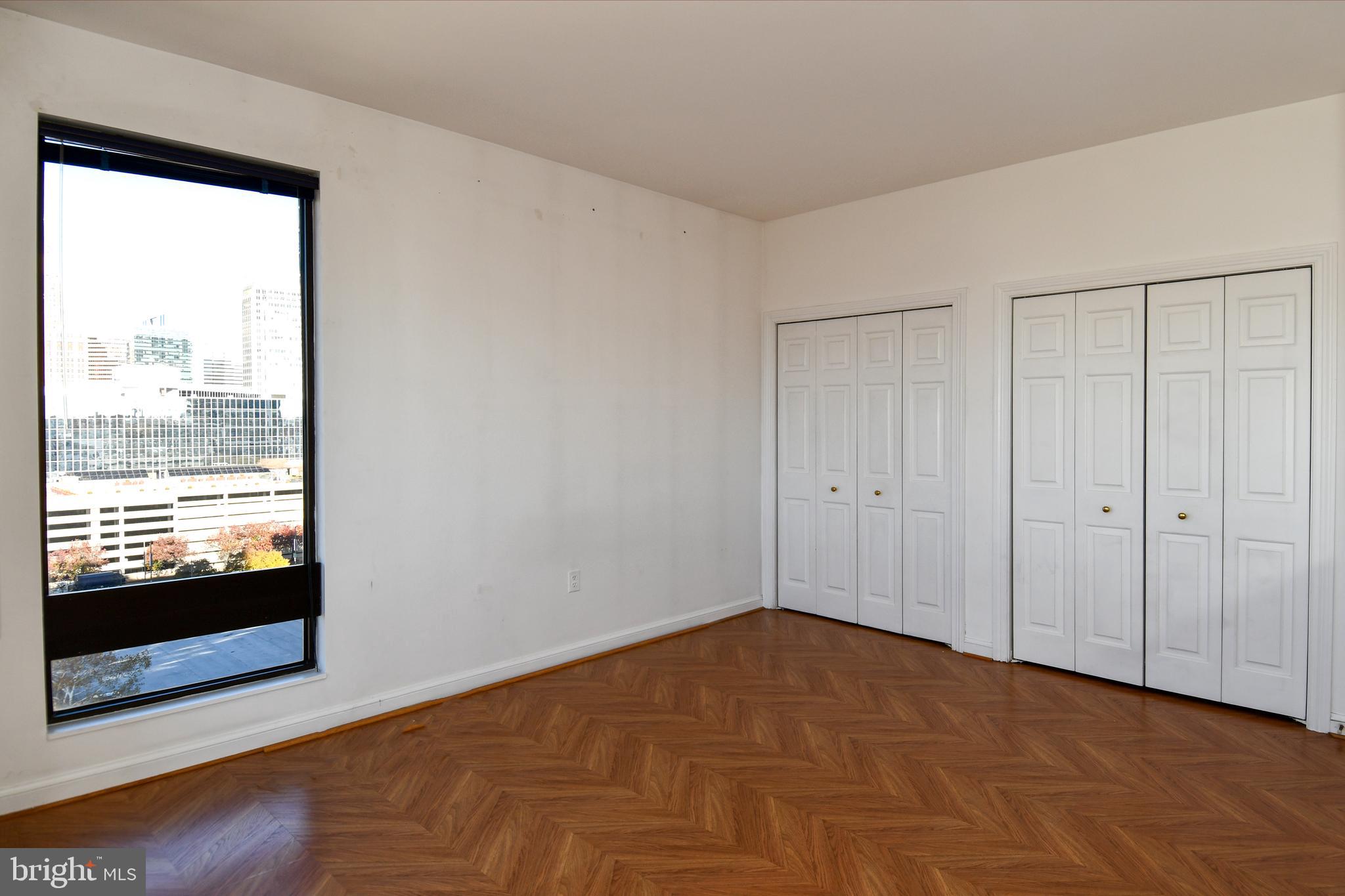 10 East Lee Street, Unit 809 Baltimore, MD 21202 - Photo 24 of 58 a view of an empty room with wooden floor and a window