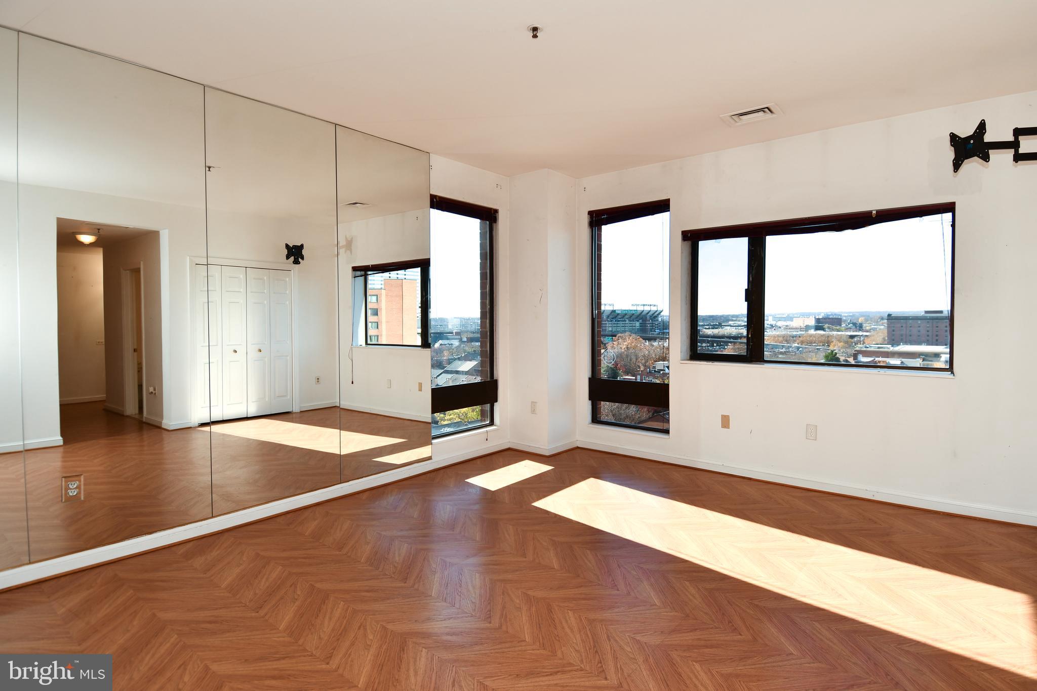 10 East Lee Street, Unit 809 Baltimore, MD 21202 - Photo 31 of 58 a view of an empty room with window and wooden floor