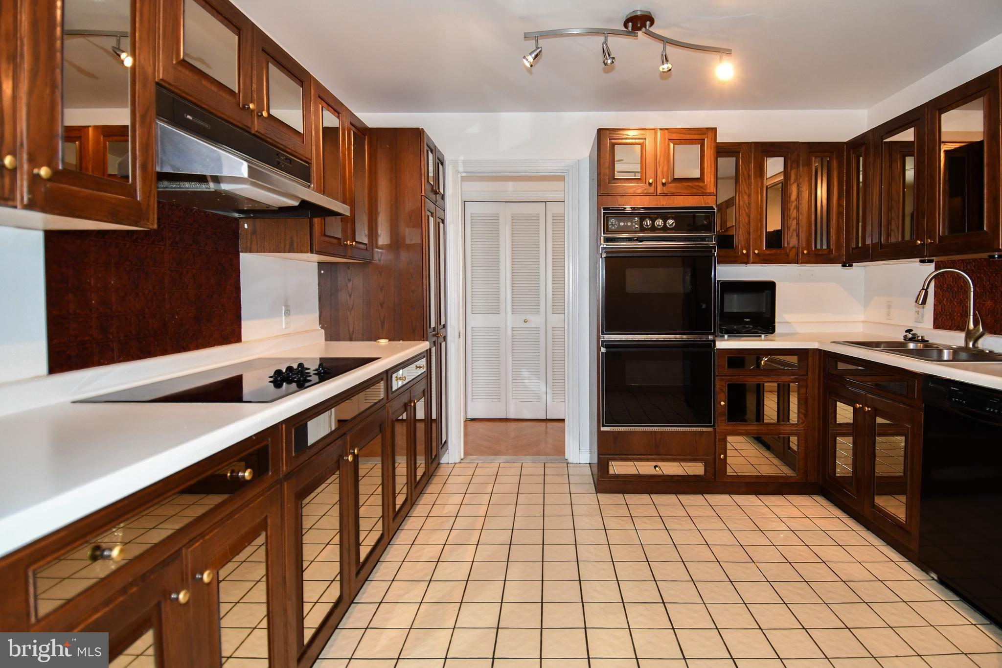 10 East Lee Street, Unit 809 Baltimore, MD 21202 - Photo 55 of 58 a large kitchen with stainless steel appliances kitchen island granite countertop a refrigerator and a stove top oven