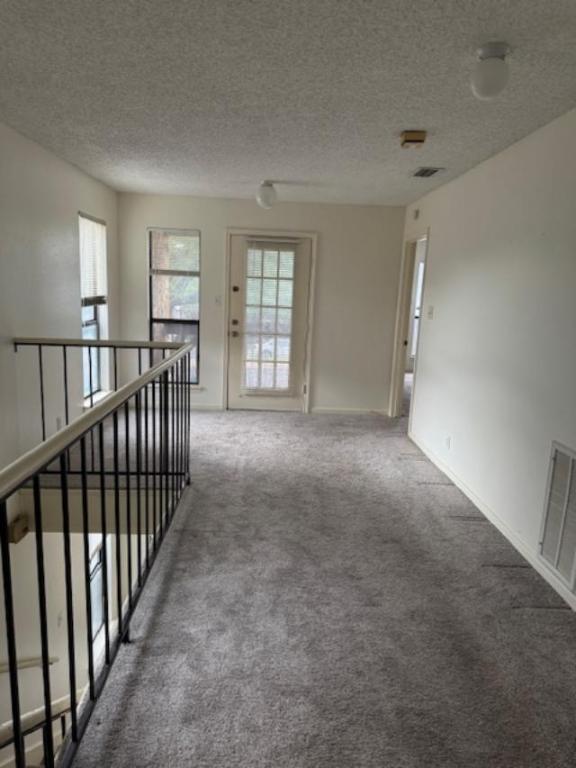 8333 Fathom Circle, Unit B Austin, TX 78750 - Photo 18 of 21 Hallway with carpet flooring, a textured ceiling, and an upstairs landing