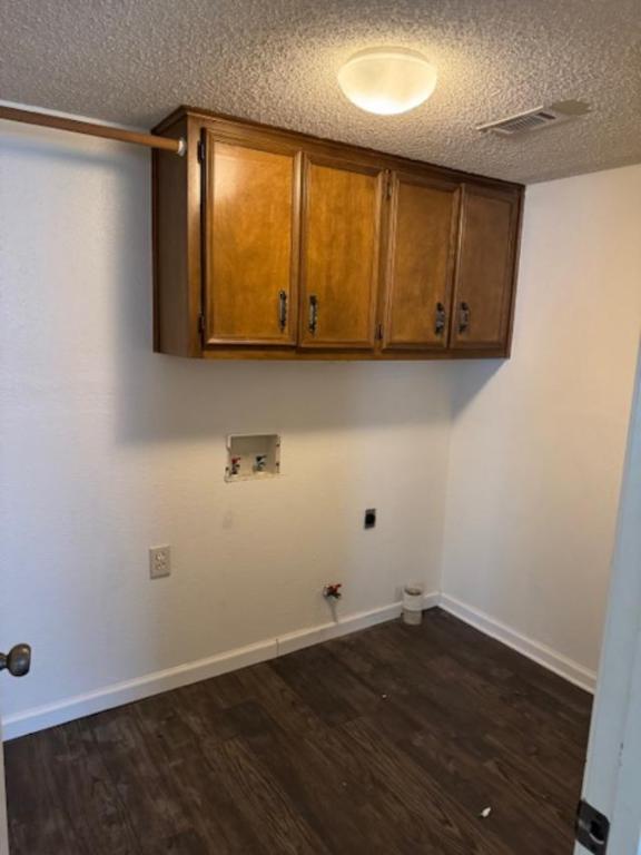 8333 Fathom Circle, Unit B Austin, TX 78750 - Photo 19 of 21 Laundry room with gas dryer hookup, dark wood-style flooring, washer hookup, a textured ceiling, and cabinet space