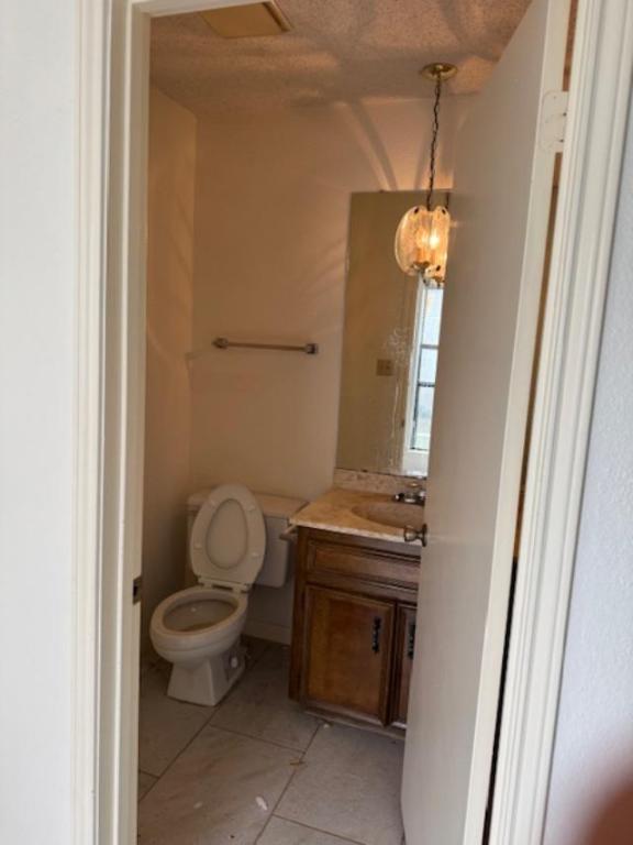 8333 Fathom Circle, Unit B Austin, TX 78750 - Photo 6 of 21 Half bath featuring vanity, a textured ceiling, and light tile patterned floors