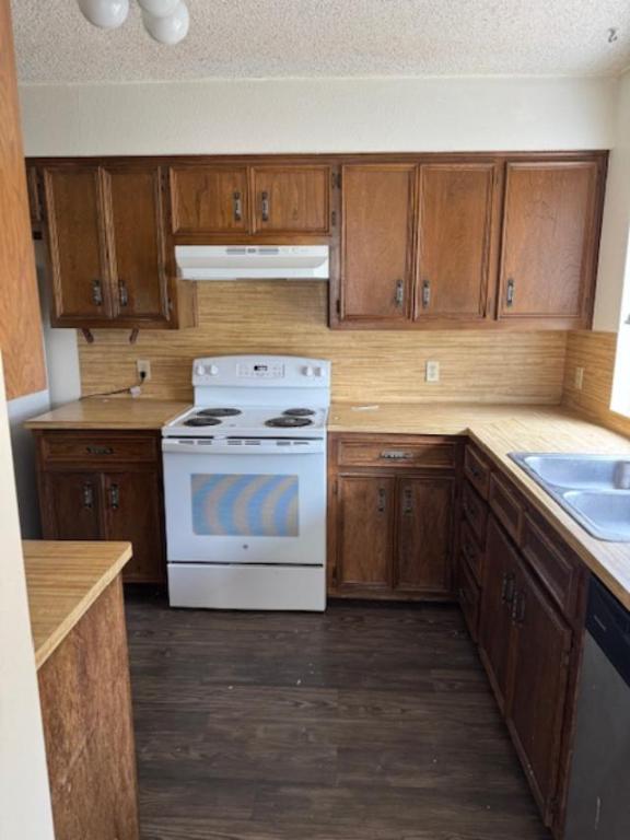 8333 Fathom Circle, Unit B Austin, TX 78750 - Photo 7 of 21 Kitchen featuring white range with electric stovetop, a textured ceiling, light countertops, under cabinet range hood, and dark wood-style flooring