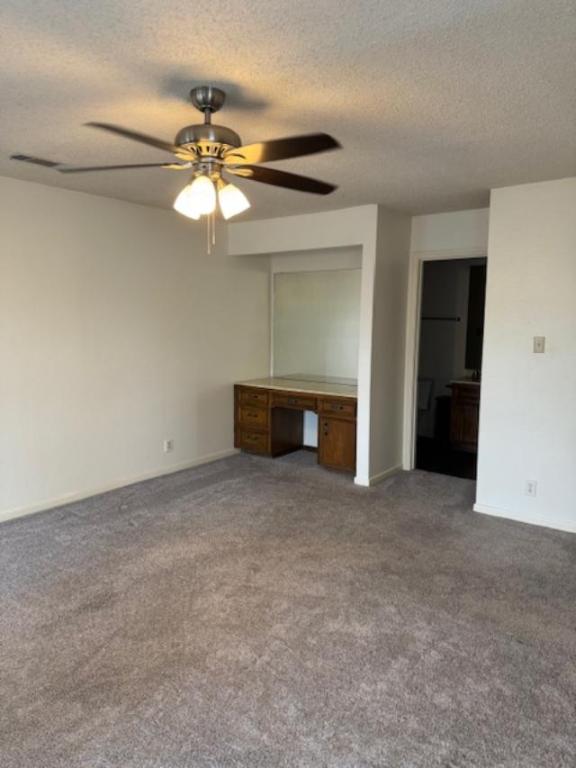 8333 Fathom Circle, Unit B Austin, TX 78750 - Photo 10 of 21 Unfurnished bedroom featuring a desk, a textured ceiling, carpet flooring, ceiling fan, and ensuite bathroom