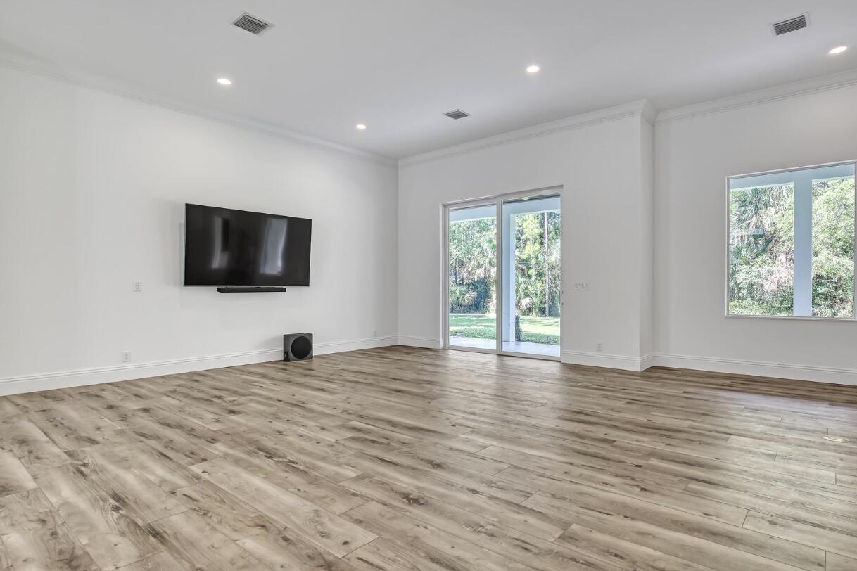 11871 Randolph Siding Road Jupiter, FL 33478 - Photo 16 of 51 a view of a livingroom with a flat screen tv wooden floor and window