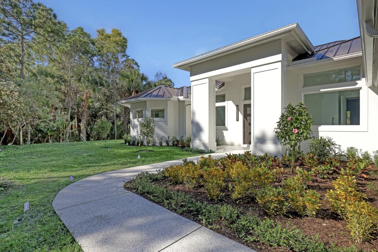 11871 Randolph Siding Road Jupiter, FL 33478 - Photo 3 of 51 front view of a house with a yard