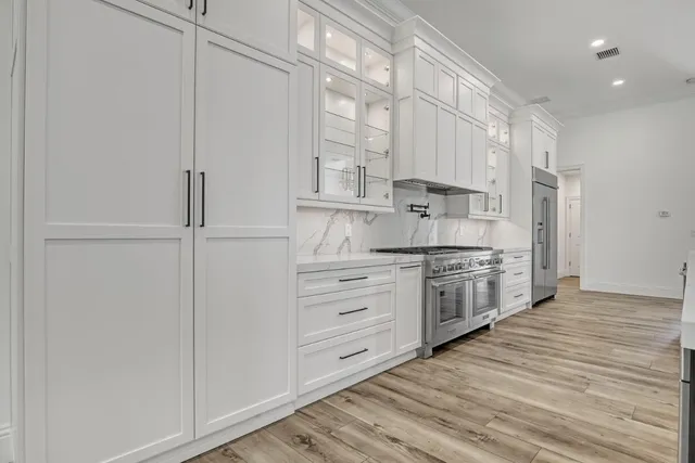 an empty room with wooden floor ceiling fan and windows