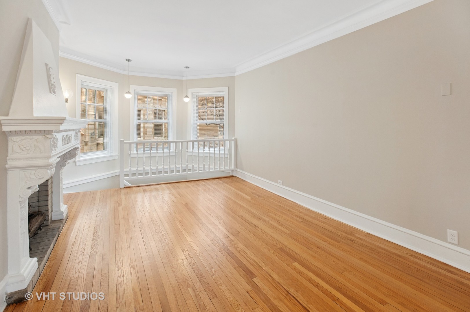 550 West Brompton Avenue, Unit 1S Chicago, IL 60657 - Photo 5 of 28 an empty room with wooden floor and a fireplace