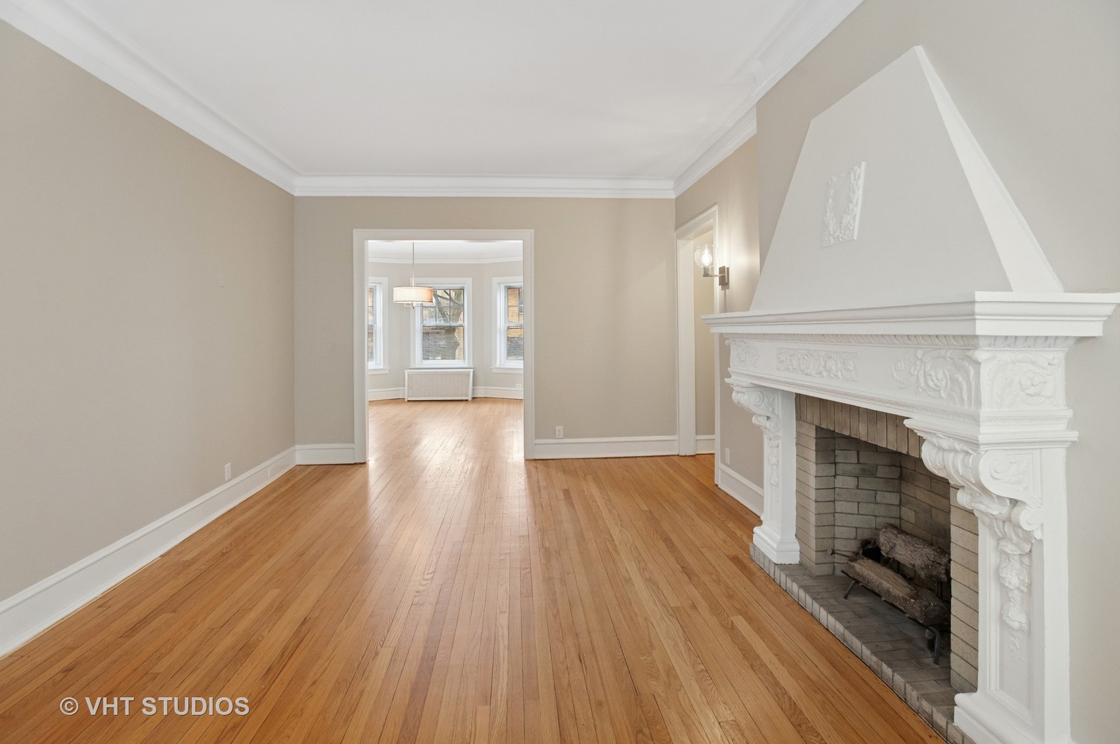 550 West Brompton Avenue, Unit 1S Chicago, IL 60657 - Photo 7 of 28 a view of an empty room with wooden floor fireplace and a window