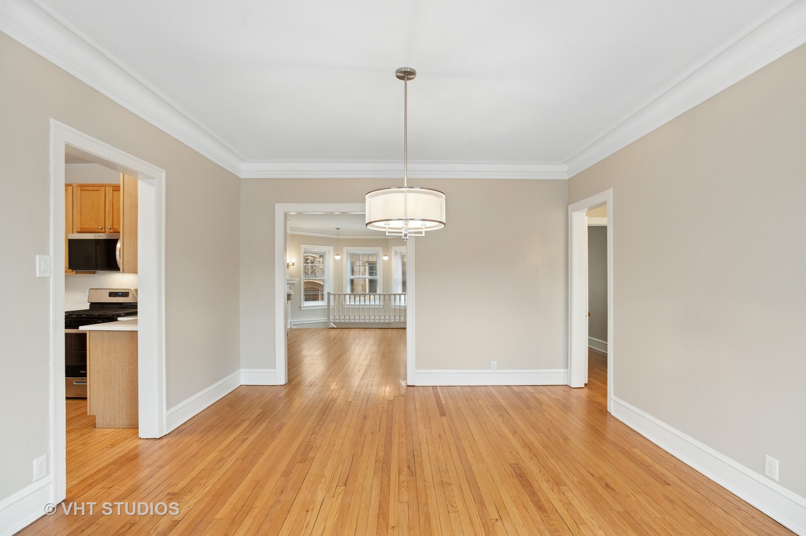 550 West Brompton Avenue, Unit 1S Chicago, IL 60657 - Photo 10 of 28 a view of a room with wooden floor staircase and a kitchen