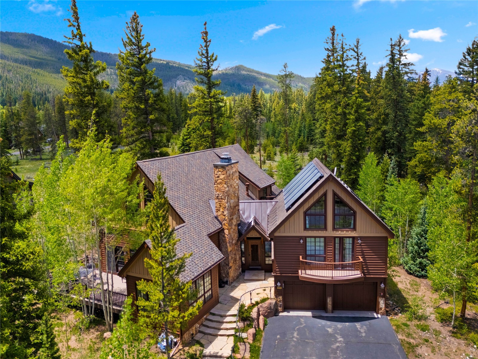 840 Penstemon Road Keystone, CO 80435 - Photo 1 of 50 View of front of house featuring a wooded view, board and batten siding, an attached garage, stone siding, and driveway