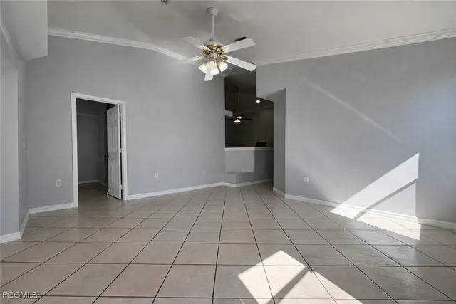 a view of an empty room and chandelier fan