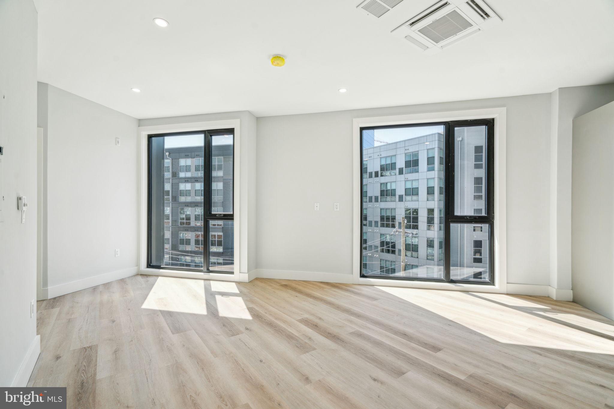3748-9 Lancaster Avenue, Unit 211 Philadelphia, PA 19104 - Photo 12 of 29 an empty room with wooden floor and windows