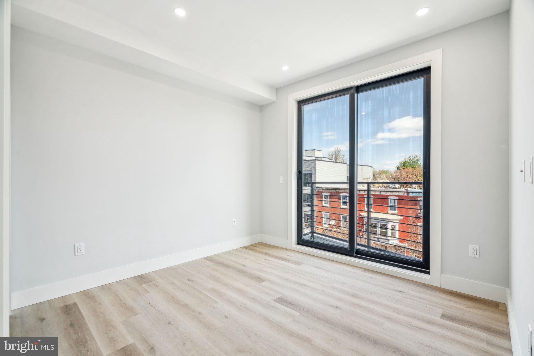 3748-9 Lancaster Avenue, Unit 211 Philadelphia, PA 19104 - Photo 17 of 29 an empty room with wooden floor and windows