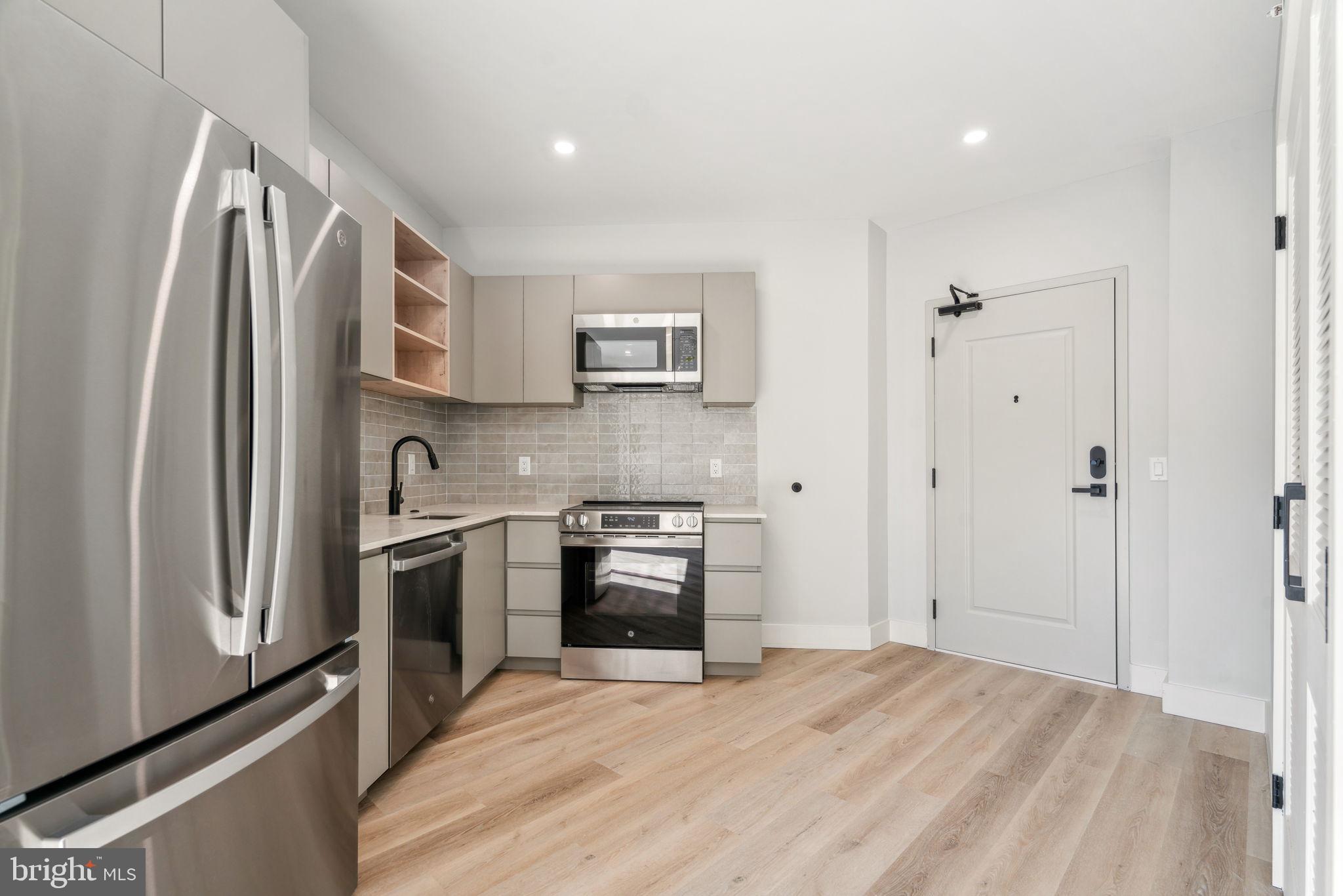 3748-9 Lancaster Avenue, Unit 211 Philadelphia, PA 19104 - Photo 8 of 29 a kitchen with stainless steel appliances granite countertop a refrigerator sink and stove