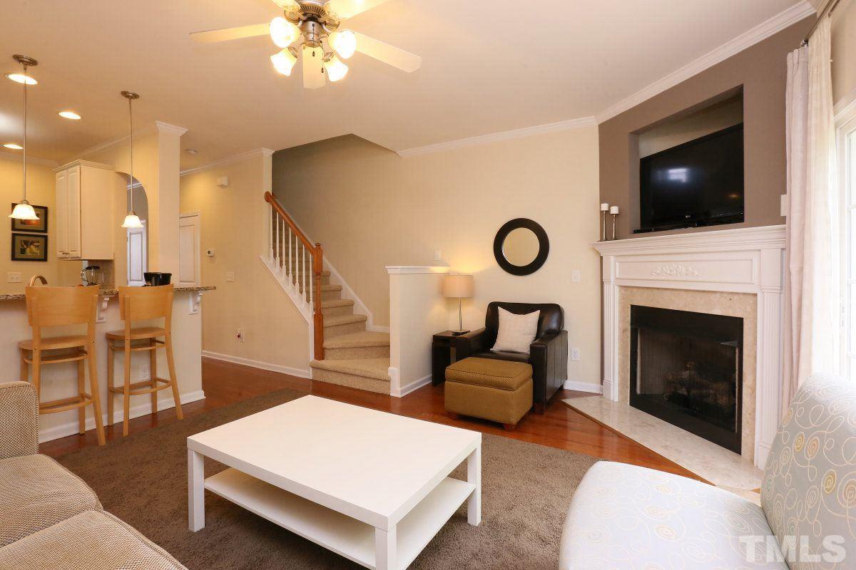 226 Cedar Elm Road Durham, NC 27713 - Photo 12 of 25 a living room with furniture a fireplace and a flat screen tv