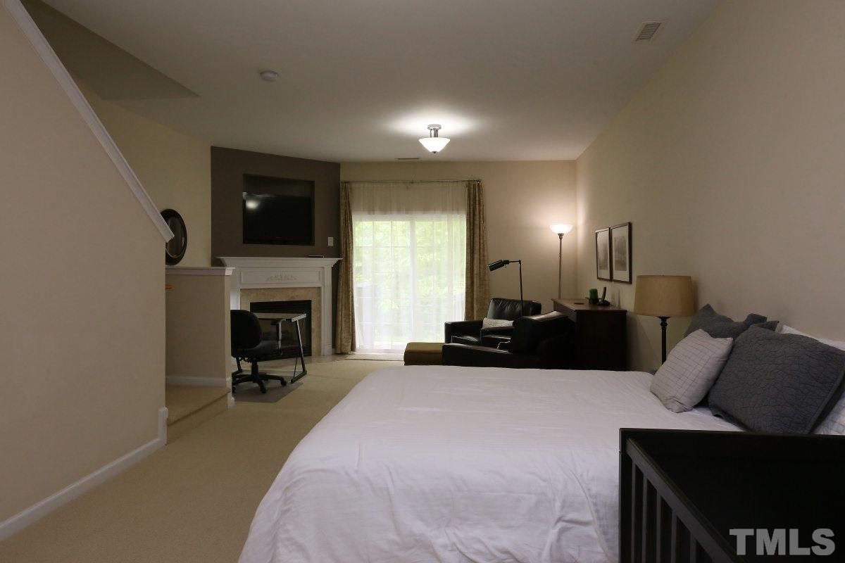 226 Cedar Elm Road Durham, NC 27713 - Photo 20 of 25 a living room with furniture a fireplace and a flat screen tv