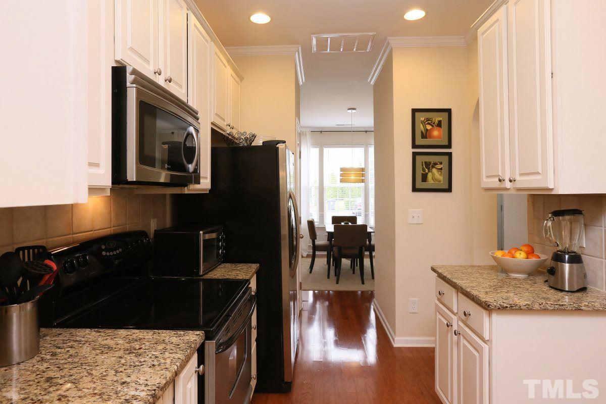 226 Cedar Elm Road Durham, NC 27713 - Photo 7 of 25 a kitchen with granite countertop stainless steel appliances and wooden cabinets