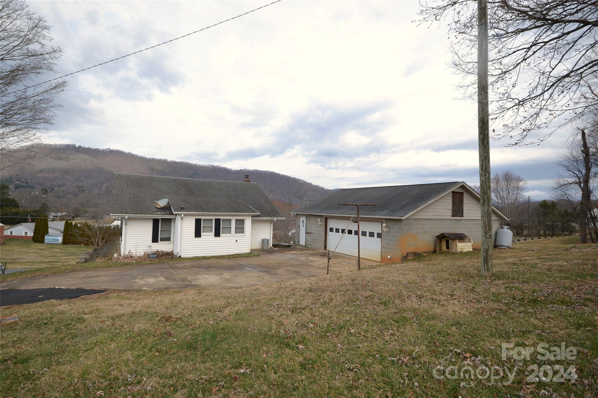 46 Murray Road Canton, NC 28716 - Photo 2 of 17 a view of a white house next to a road with big trees