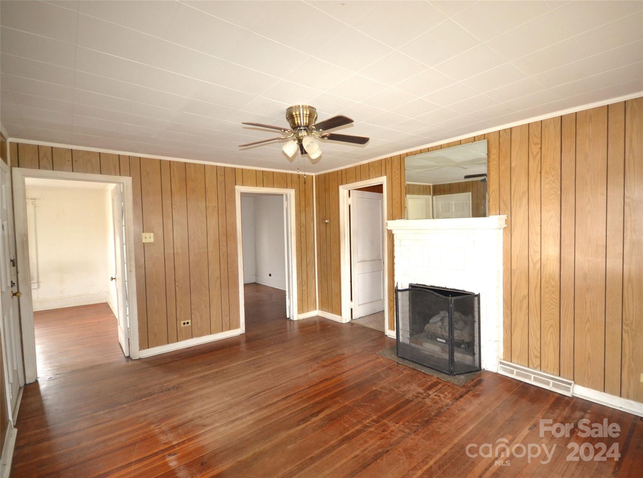 46 Murray Road Canton, NC 28716 - Photo 10 of 17 an empty room with wooden floor fireplace and windows