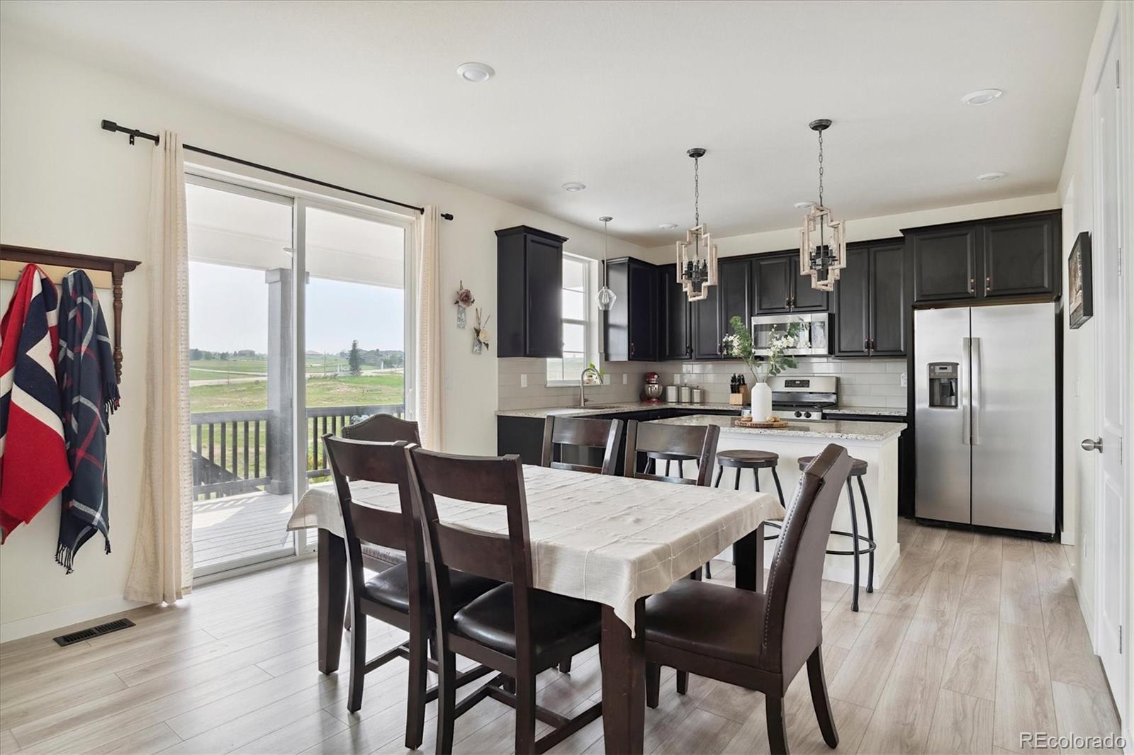 1142 Williams Loop Elizabeth, CO 80107 - Photo 11 of 38 a kitchen with stainless steel appliances granite countertop a stove a refrigerator a kitchen island a dining table and chairs