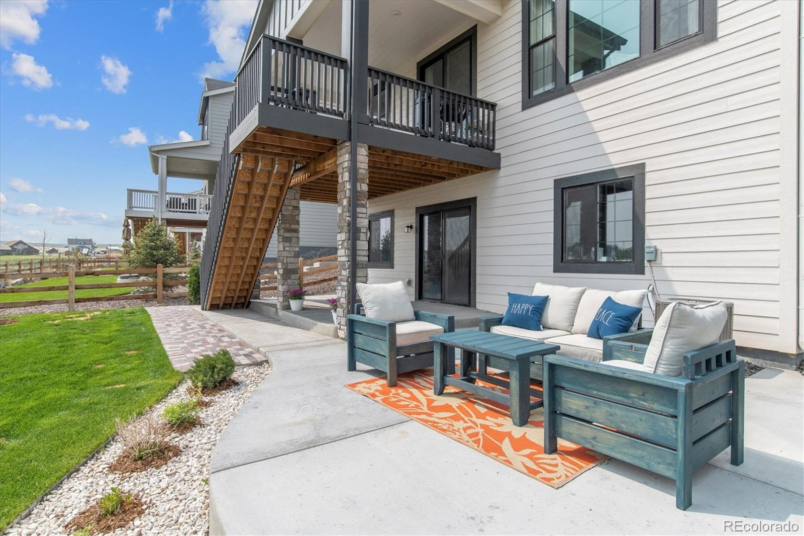 1142 Williams Loop Elizabeth, CO 80107 - Photo 33 of 38 a view of a patio with couches table and chairs with wooden fence and plants