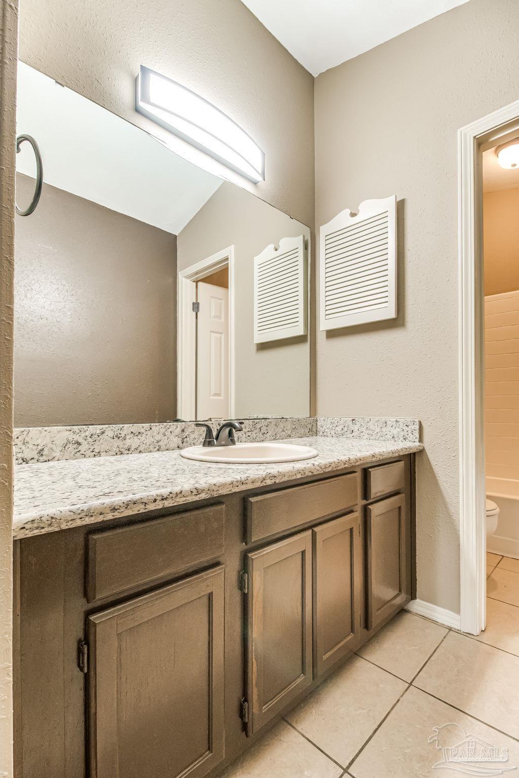 4554 Northpointe Place Pensacola, FL 32514 - Photo 11 of 42 a bathroom with a granite countertop sink and a mirror